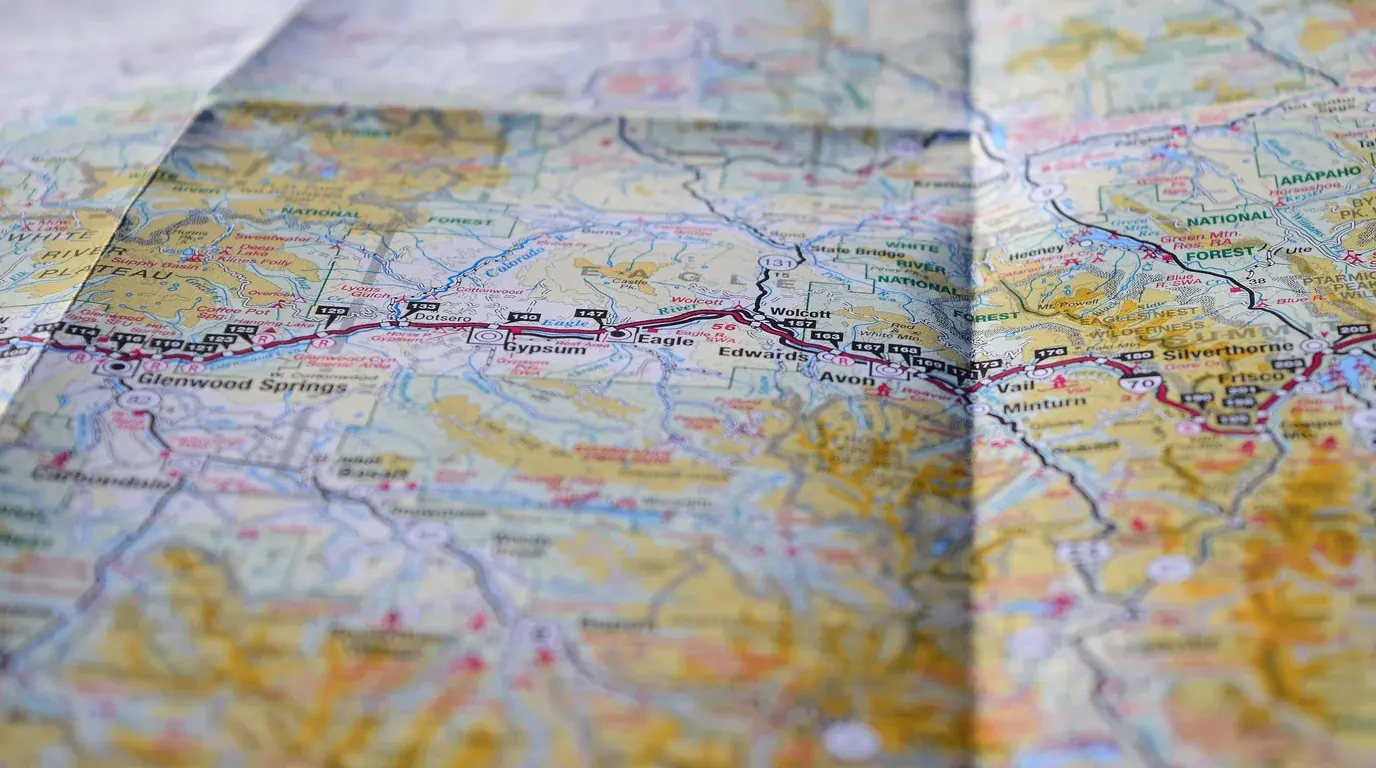 Close-up of a folded road map, a highway route traced through towns across the mountains.