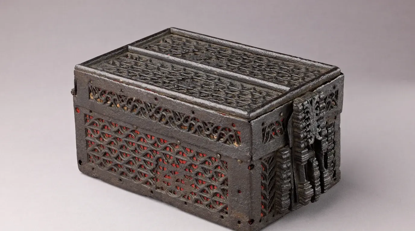 A late-15th-century French iron strongbox with pierced tracery panels and a heavy lock plate.
