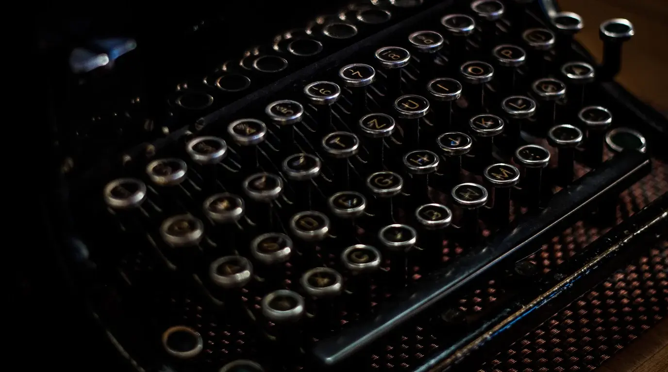The round keys of a vintage typewriter catching the light against a dark background.