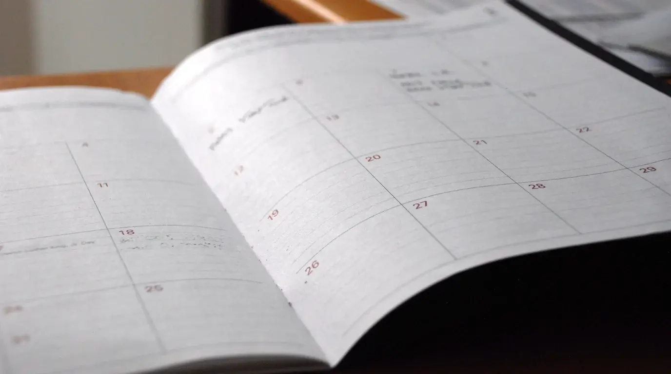 An open monthly planner with a few handwritten notes in the date boxes.