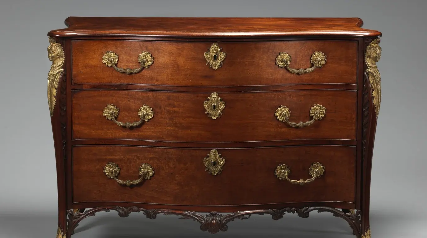 An 18th-century mahogany chest of three drawers with gilt-bronze handles and mounts.